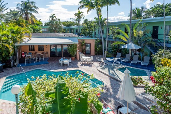 Een buitenzwembad, parasols bij het zwembad en ligstoelen