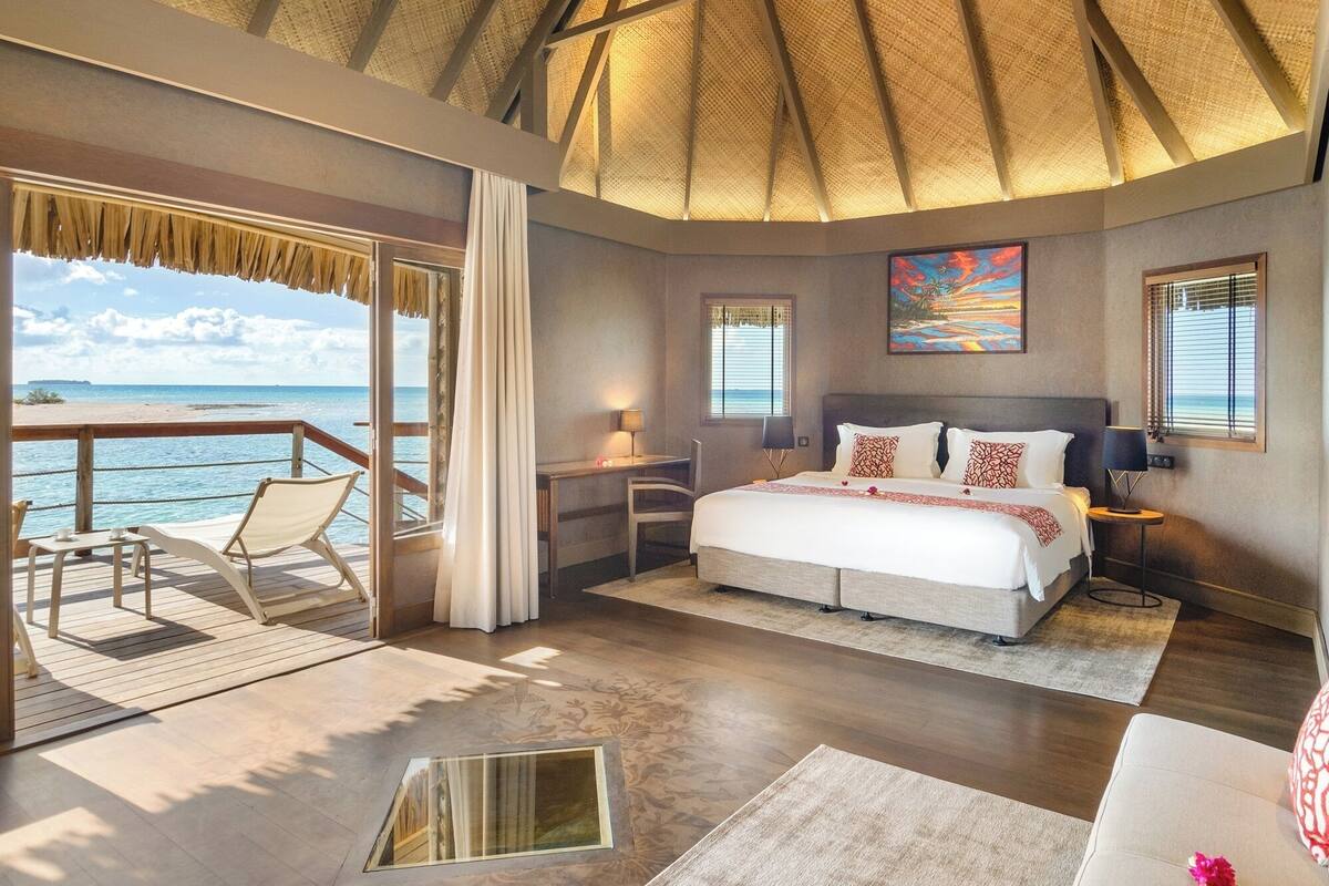 Une chambre avec un lit, un bureau, une chaise et une vue sur l’océan.
