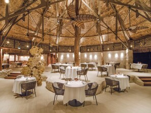 Enjoy meals in a warm and inviting dining area with a high ceiling and intricate wall patterns.