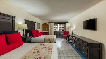 Habitación de hotel con dos camas, un escritorio, una silla, un televisor y vista al exterior.