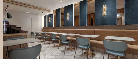 Ein stilvolles Restaurant-Interieur mit Marmorböden, Sitzmöbeln und moderner Einrichtung.