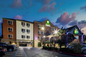 A Holiday Inn Express hotel with a parking lot and a clear sky. - Holiday Inn Express Castro Valley - I-580 by IHG (Castro Valley)
