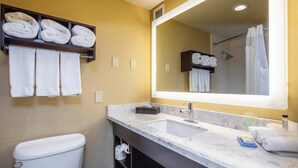 A bathroom with a toilet, sink, and mirror. There are towels on a shelf and a shower curtain. - Holiday Inn Express Castro Valley - I-580 by IHG (Castro Valley)