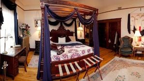 A traditional four-poster bed with a canopy, a wooden desk with a chair, and a small table with a lamp. - Beall Mansion An Elegant Bed & Breakfast Inn (Alton)