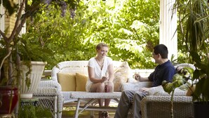 A covered outdoor seating area with wicker furniture and potted plants. - Beall Mansion An Elegant Bed & Breakfast Inn (Alton)