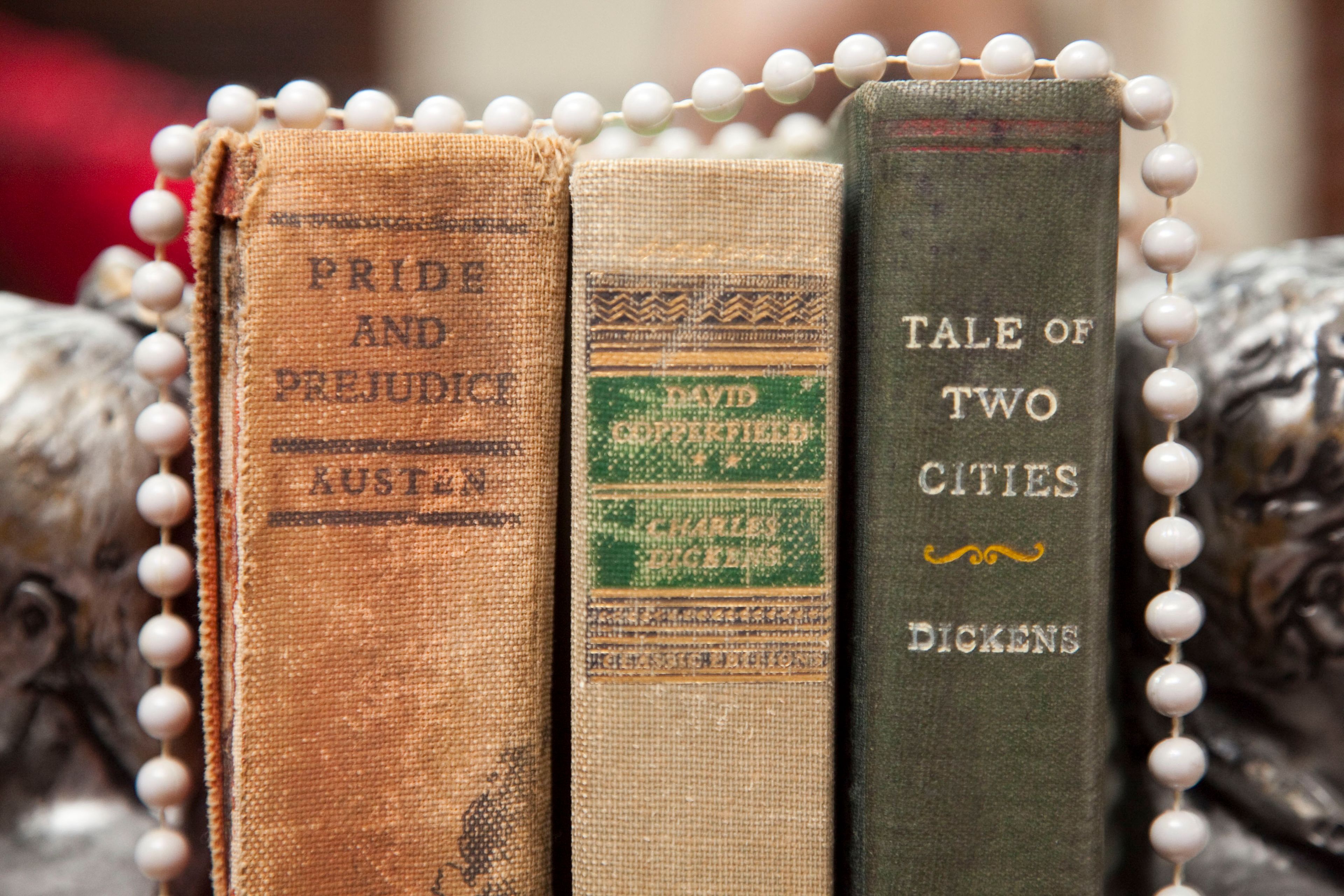 Trois livres intitulés « Orgueil et Préjugés », « David Copperfield » et « Un conte de deux villes », de Dickens, disposés verticalement.