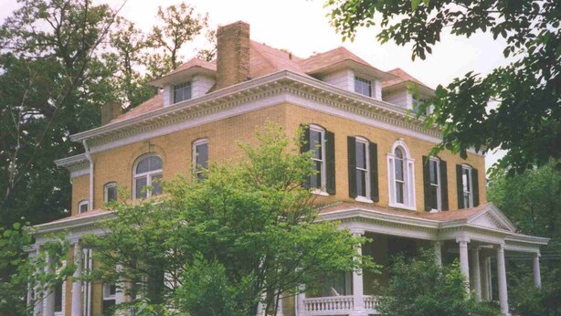 A large, two-story brick house with a symmetrical facade, a central entrance with columns, and a covered porch. - Beall Mansion An Elegant Bed & Breakfast Inn (Alton)