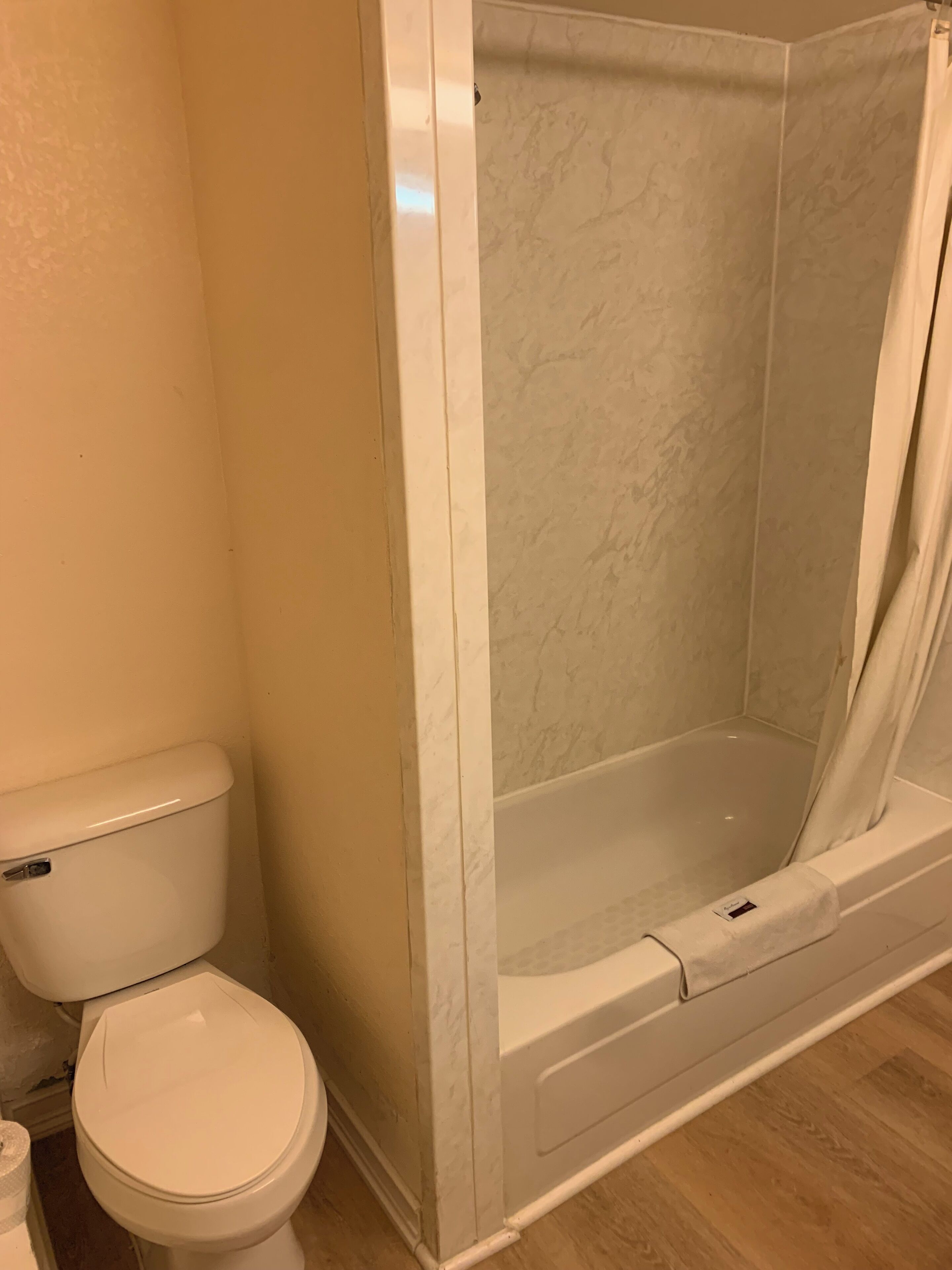 Un bagno con il water, un box doccia e una vasca da bagno.
