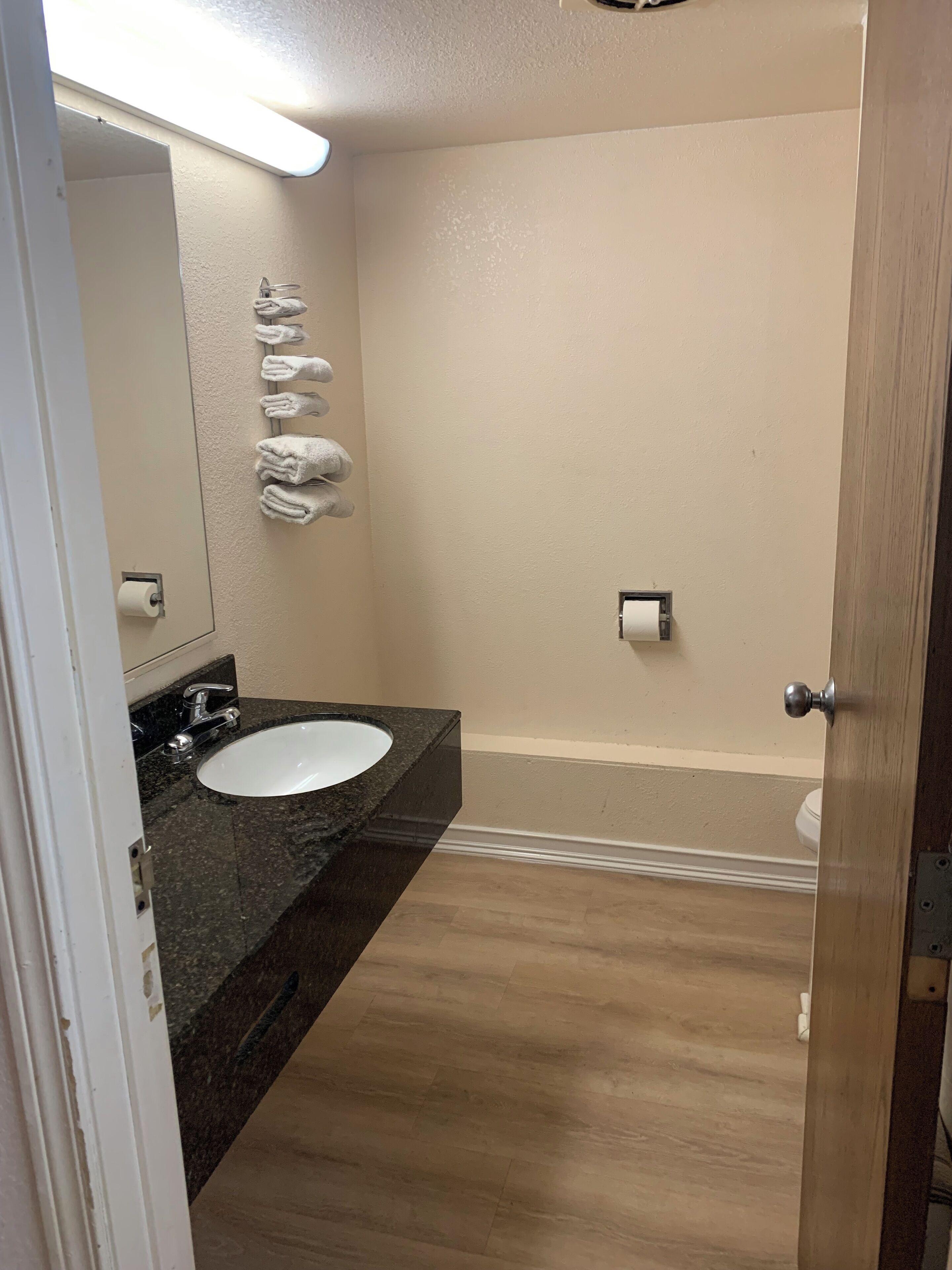 A bathroom with a white sink, a mirror, and a towel rack.