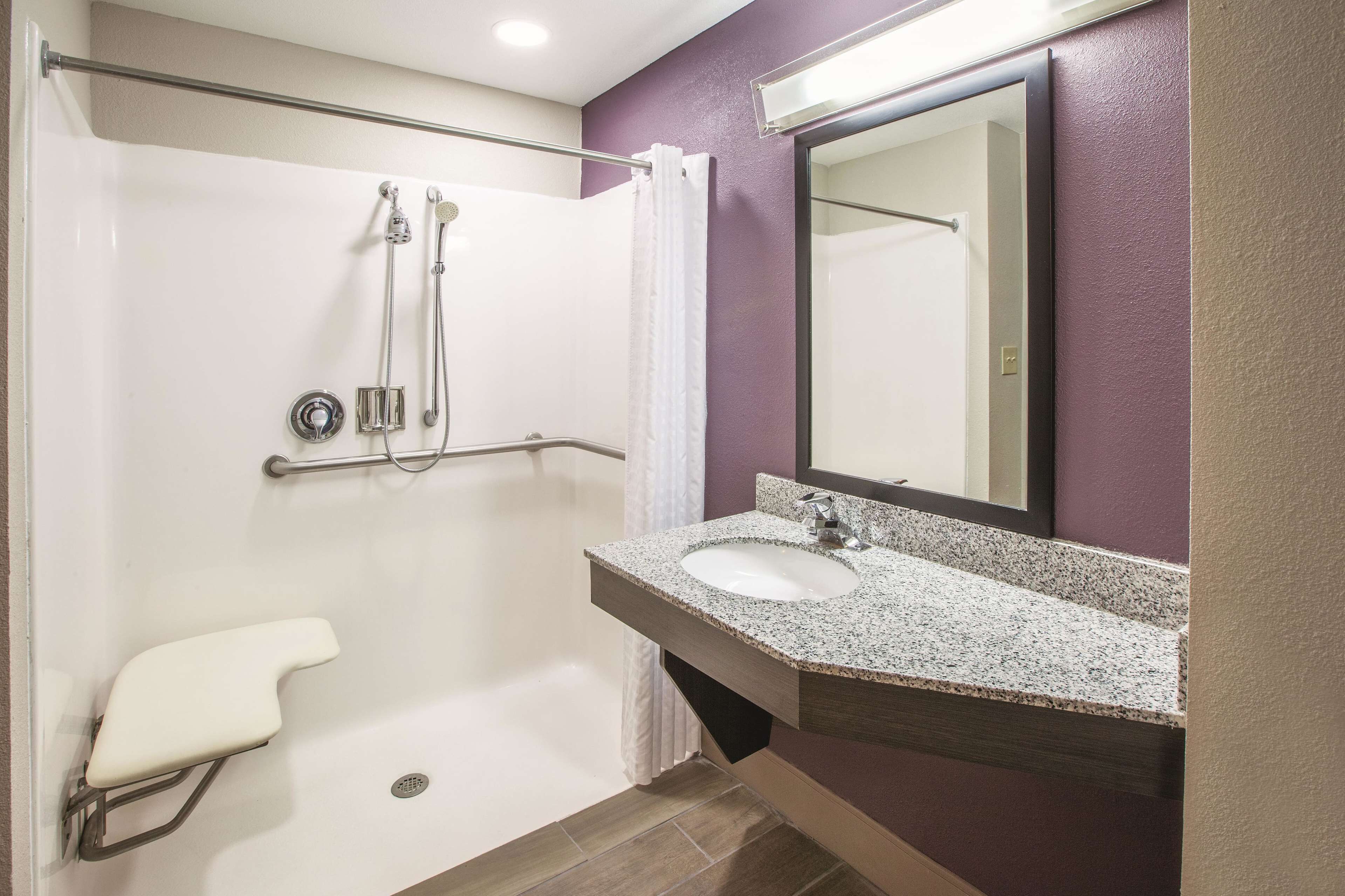 A bathroom with a shower, toilet, and sink.