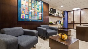 Welcome to our reception area, featuring a comfortable seating area, a reception desk, and a beautiful abstract art piece.