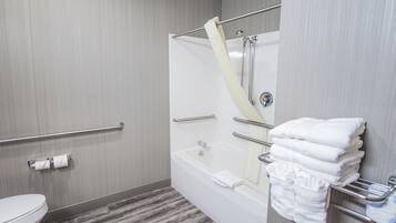 A bathroom with a shower, toilet, and towel rack.