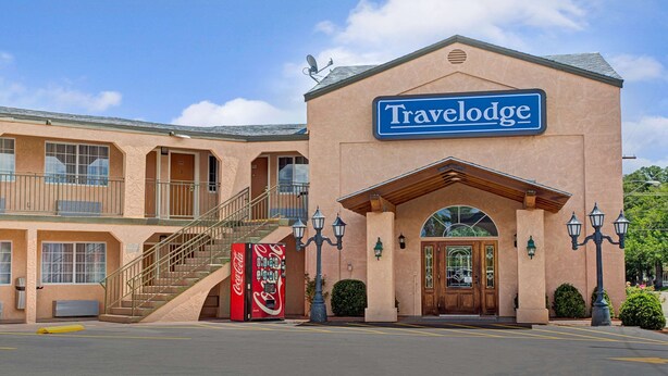 Un hôtel Travelodge avec une enseigne bien visible, un distributeur automatique de Coca-Cola et un escalier menant à un étage supérieur.