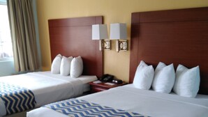 Une chambre d’hôtel avec deux lits, une table de chevet, une horloge et une fenêtre avec des rideaux.