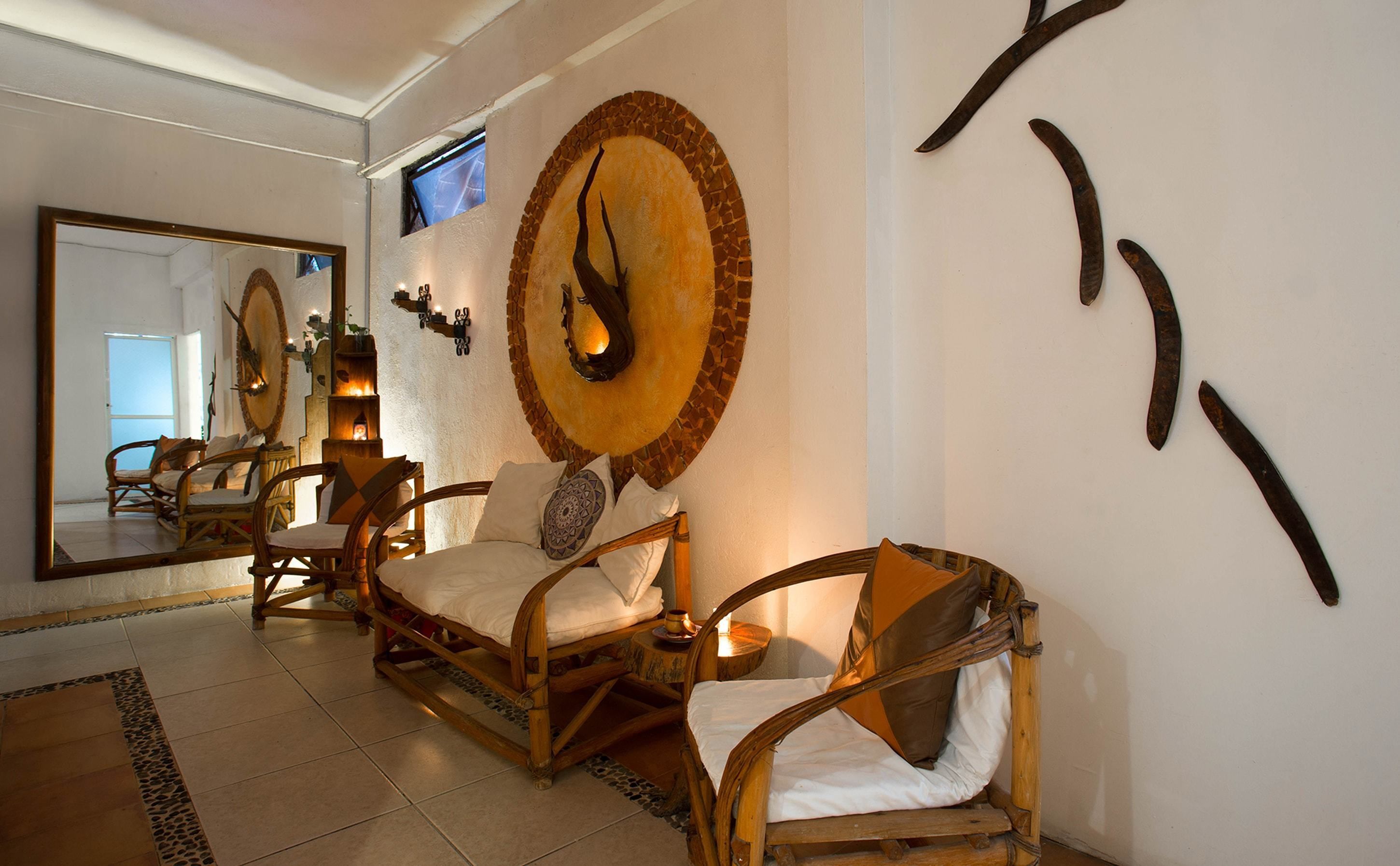 A room with a large mirror, wooden furniture, and a decorative wall piece.