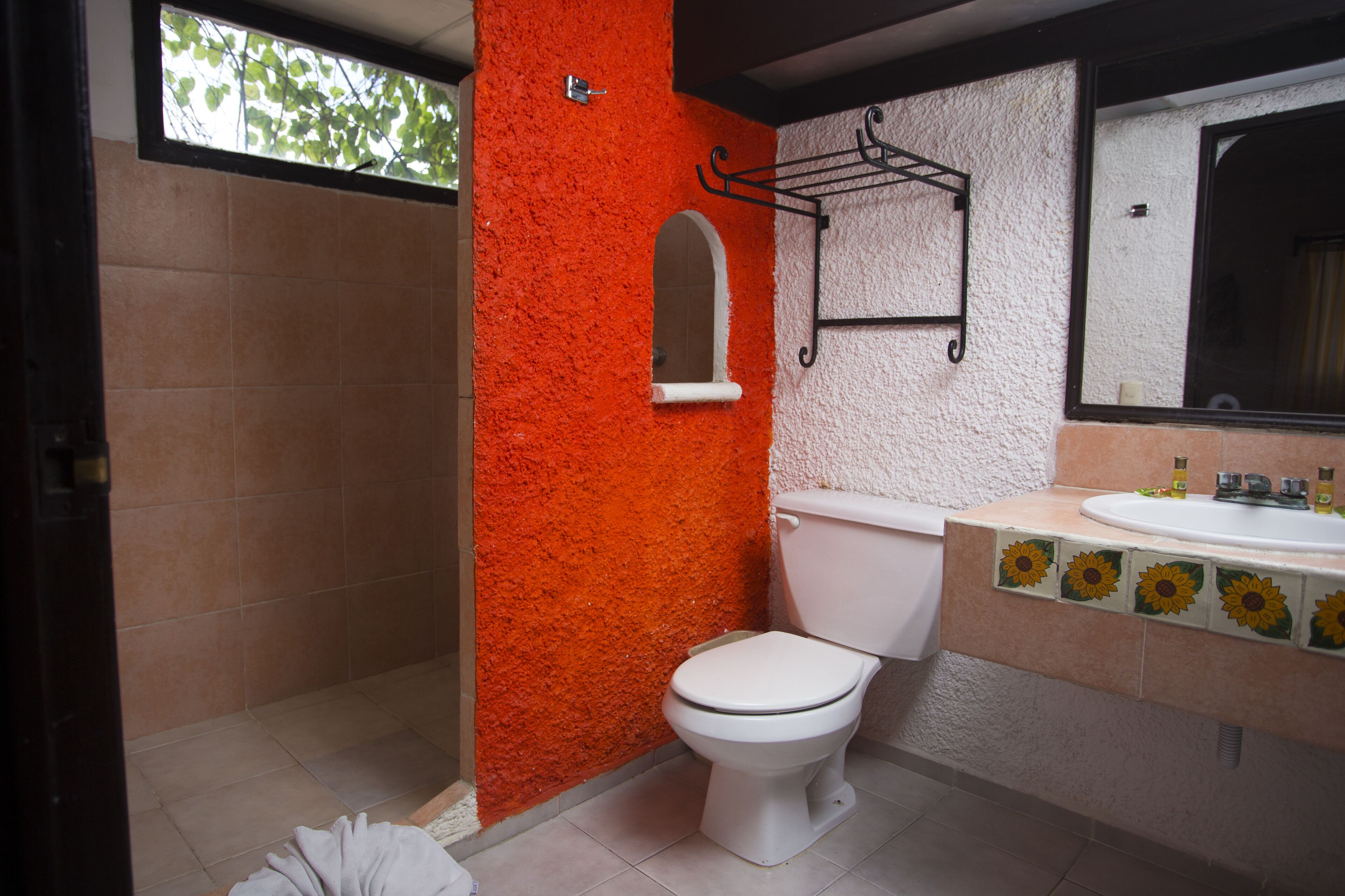 Un bagno con il water bianco, un lavabo con specchio e una cabina doccia.