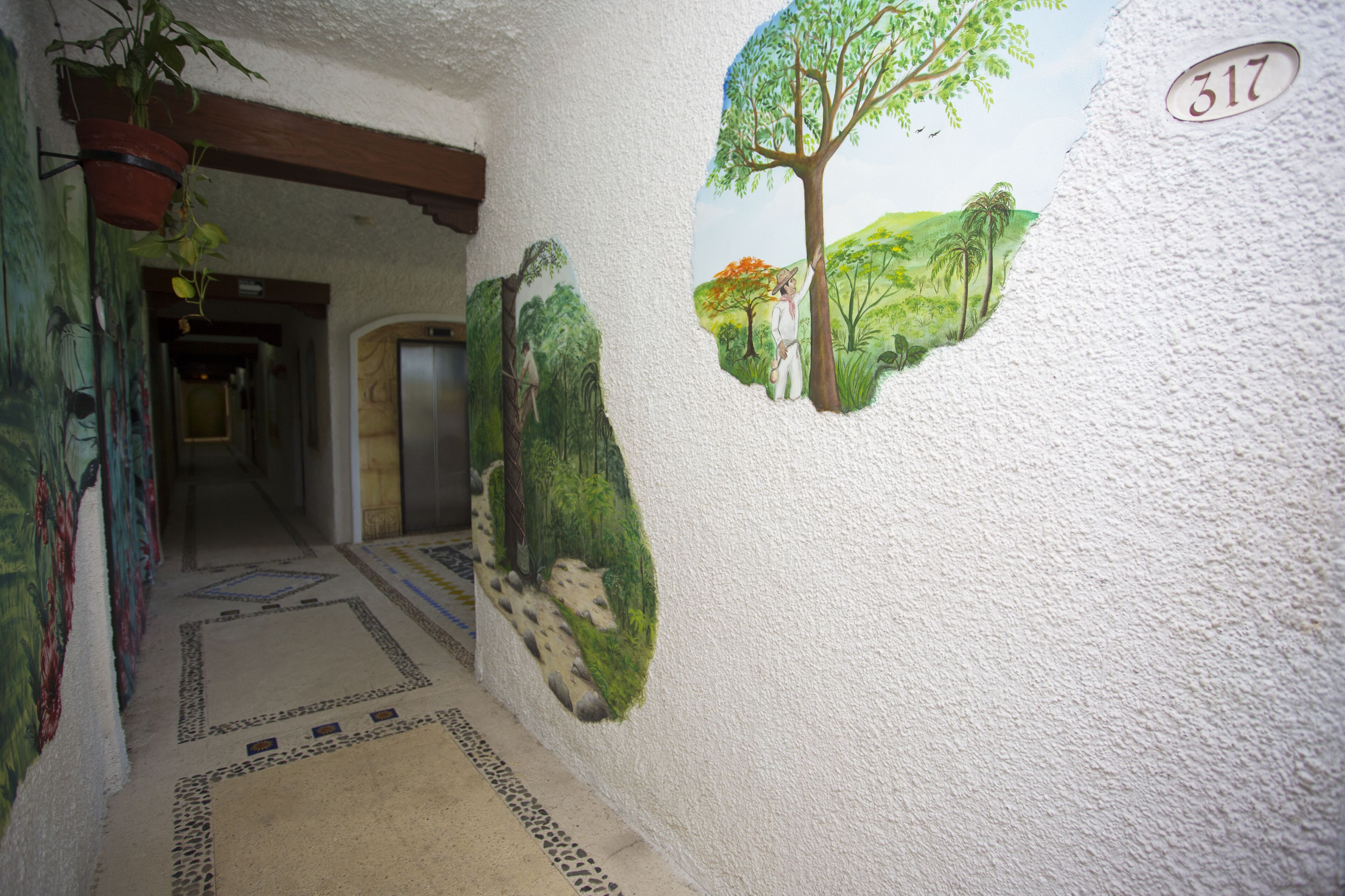 A hallway with a mural of a forest scene and a number '317' on the wall.