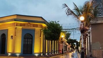 A street with buildings featuring classical architecture, including columns and arched windows.