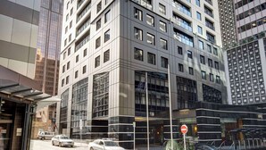 A high-rise building with a modern architectural design, featuring a prominent entrance with a glass facade and a visible sign for a hotel or office. - Adina Citylife Auckland (Auckland)