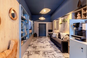 A modern hallway with a marble floor, wooden shelves, a sofa, and pendant lighting. - Garner Hotel Vienna by IHG (Vienna)