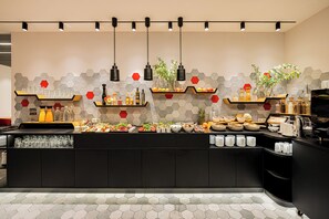 A modern kitchen with a central island, hexagonal tile backsplash, and various food items displayed on shelves. - TOP VCH Hotel Michaelis Leipzig (Leipzig)