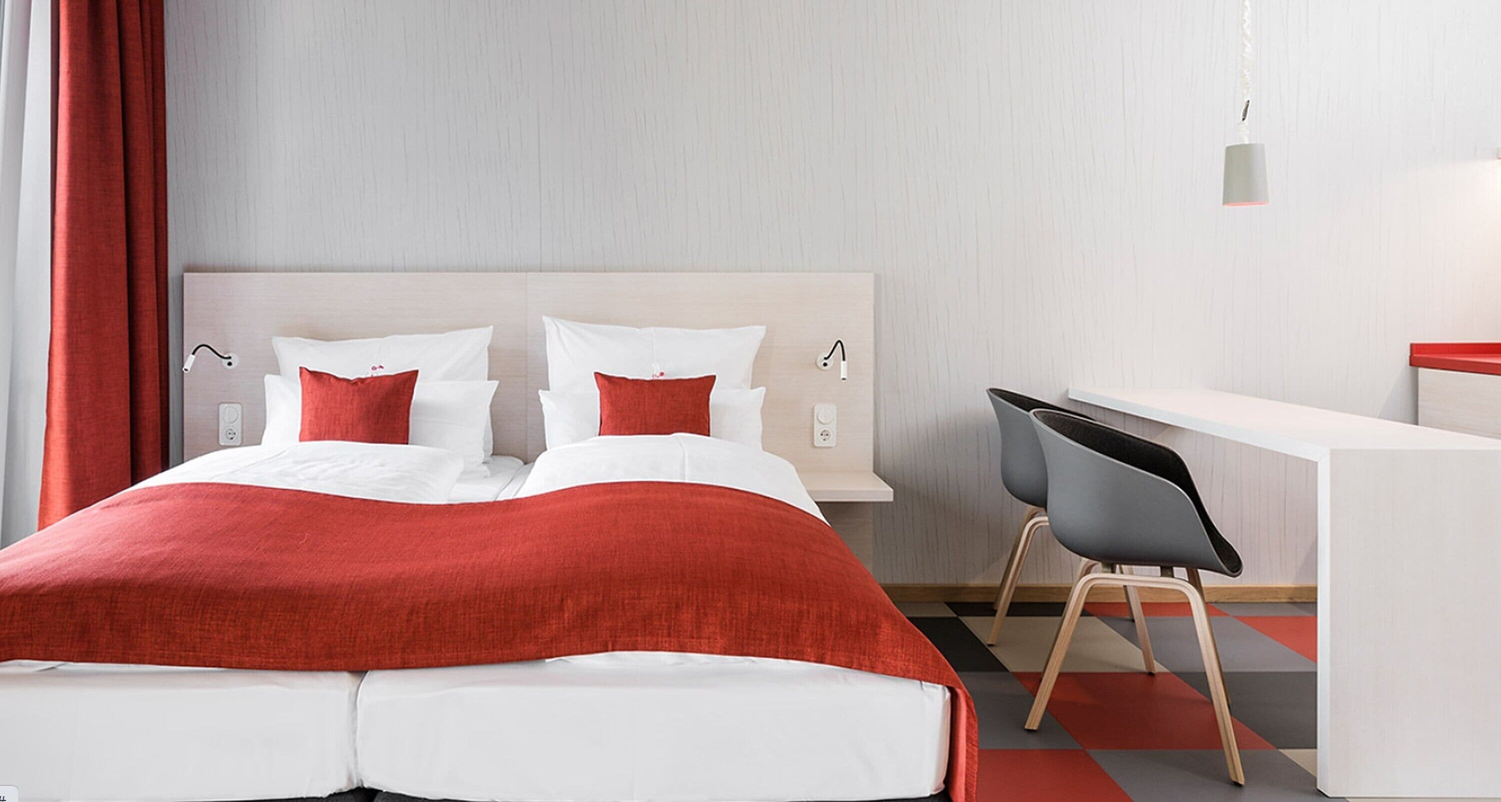 Una habitación de hotel con una cama, un escritorio y una silla.