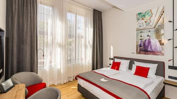 Une chambre d’hôtel moderne avec un grand lit, un bureau et une télévision.