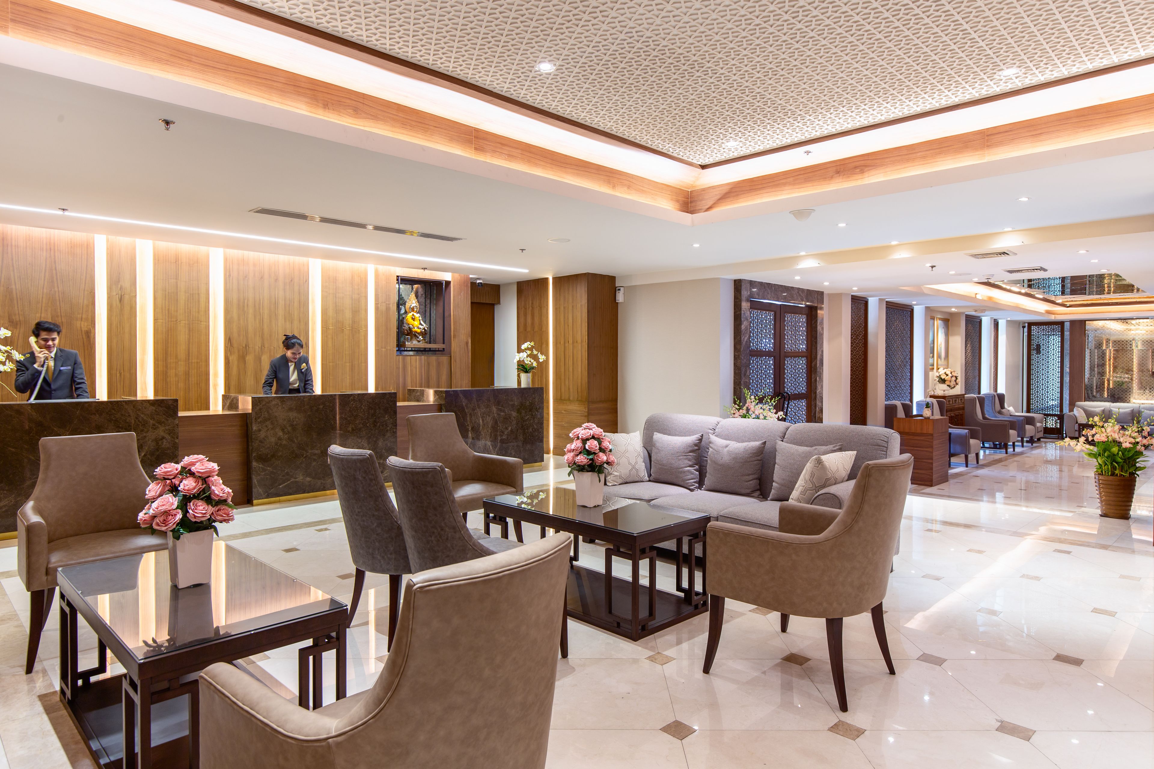 Un moderno vestíbulo de hotel con mostrador de recepción, zona de estar y un amplio ventanal.