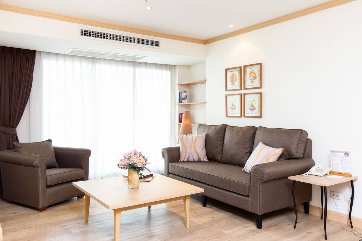A modern living room with two sofas, a coffee table, and a small side table.