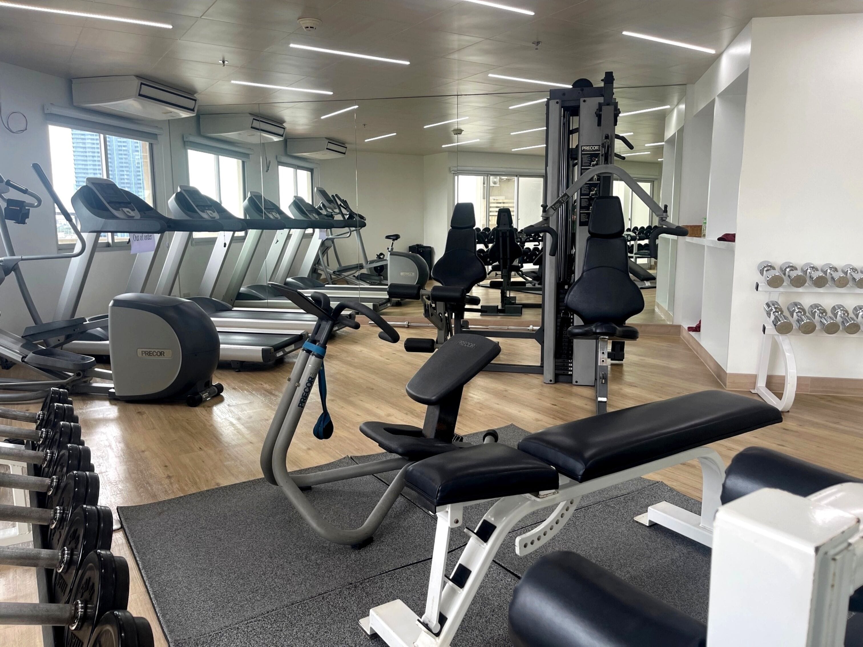 A gym with treadmills, weight machines, and dumbbells.