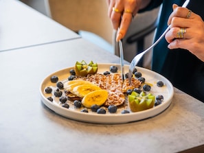 A breakfast plate with pancakes, blueberries, banana slices, and kiwi on a white plate. - ibis Berlin Mitte (Berlin)