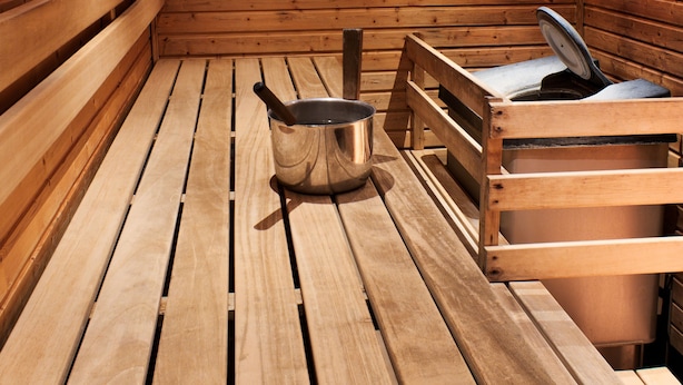 Una sauna de madera con bancos y una bañera de sauna.