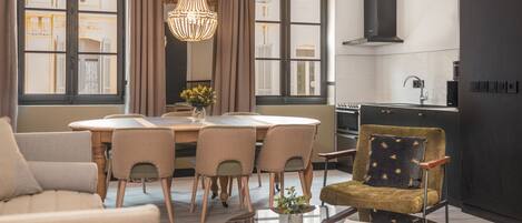 Una cocina moderna con comedor, que incluye una araña, una mesa redonda y un sofá.
