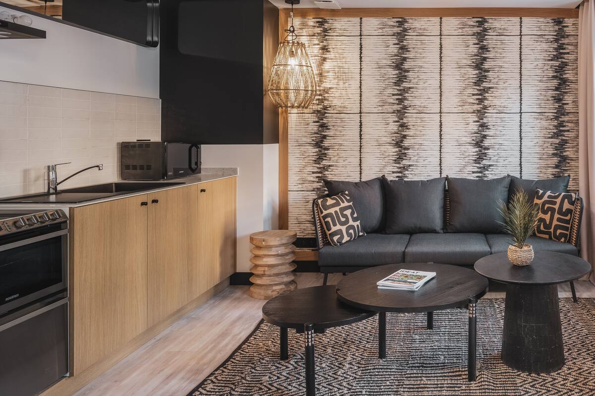 A modern kitchen with a built-in oven and microwave, a wooden cabinet, and a black countertop.