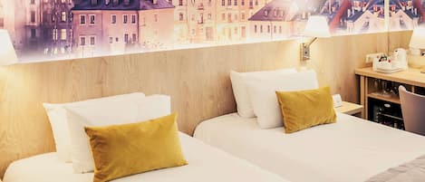 Habitación de hotel con dos camas, cabecera de madera, mesita de noche con lámpara y vistas a la ciudad.