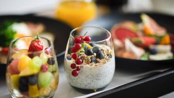 Twee glazen met fruit yoghurt parfait op een schaal.