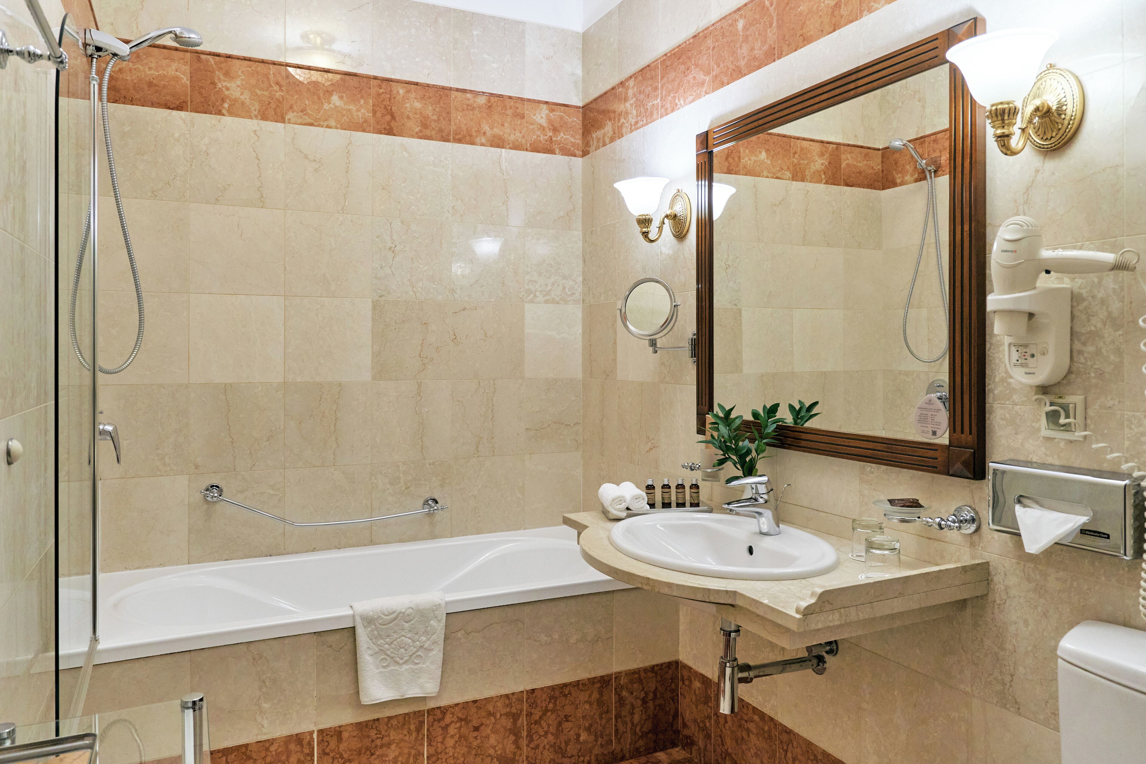 Un baño moderno con bañera, ducha, lavamanos e inodoro.