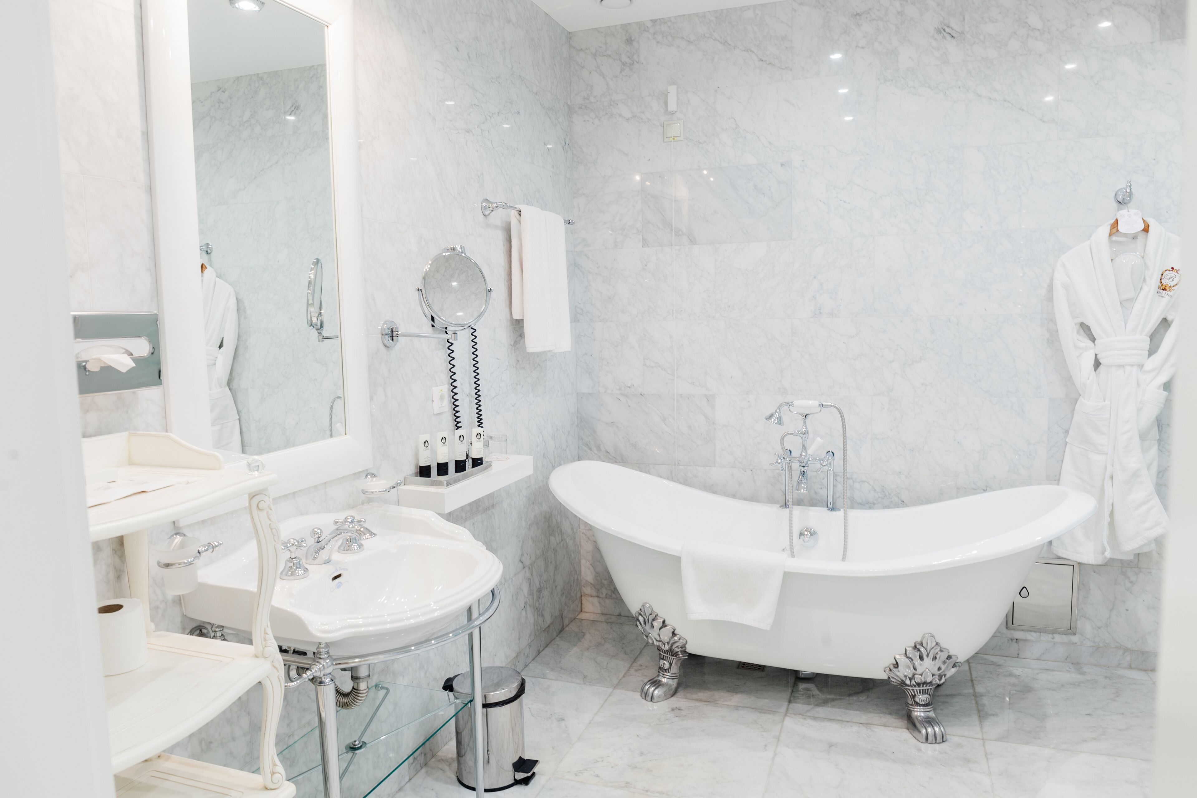 A modern bathroom with a freestanding bathtub, a large mirror, and a vanity with a sink.