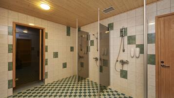 Un baño con piso a cuadros, techo de madera y cabina de ducha de vidrio.