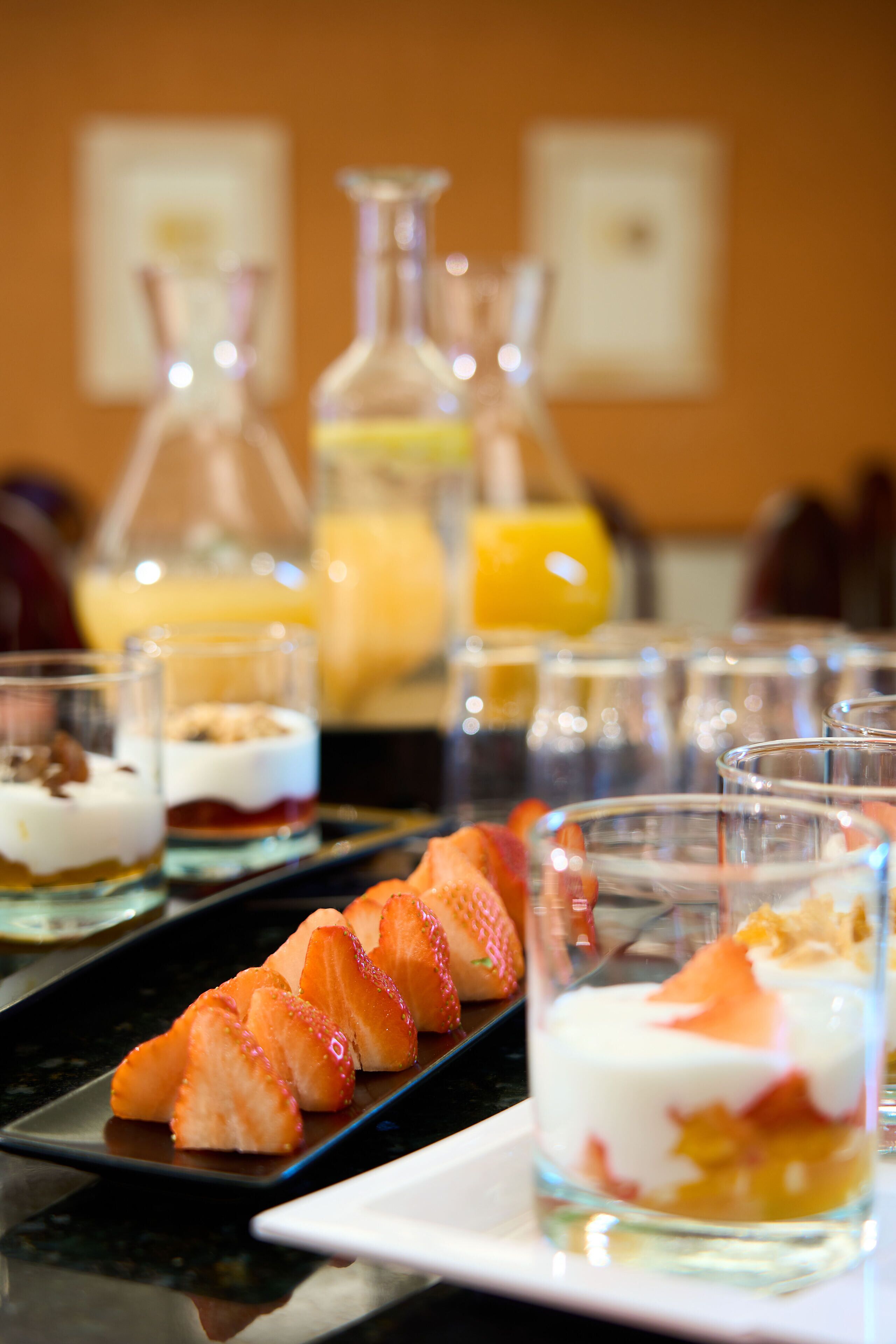 Un bufé de postres con diversas opciones de fruta y platos a base de yogur.