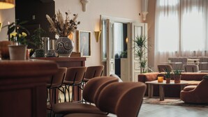 A modern lobby with a seating area, a reception desk, and decorative plants. - Home Hotel Christian IV (Kristianstad)