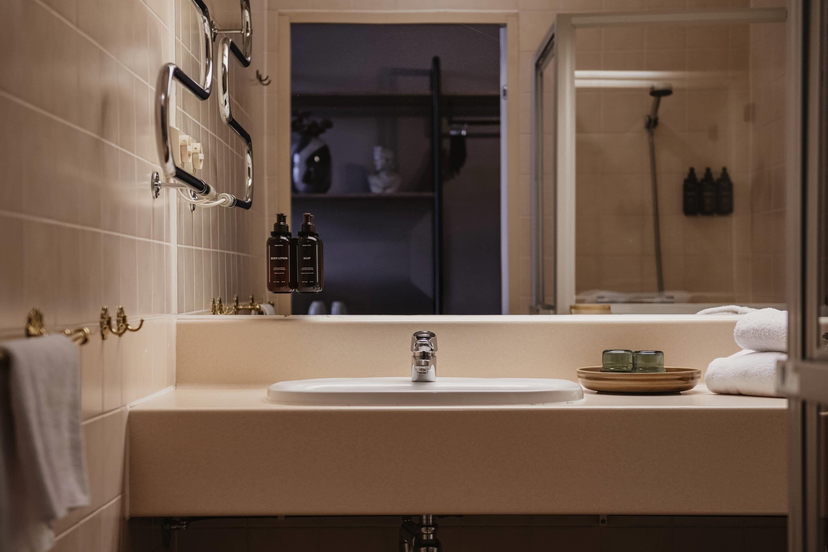 Un baño moderno con un lavamanos grande, un espejo y una zona de ducha.