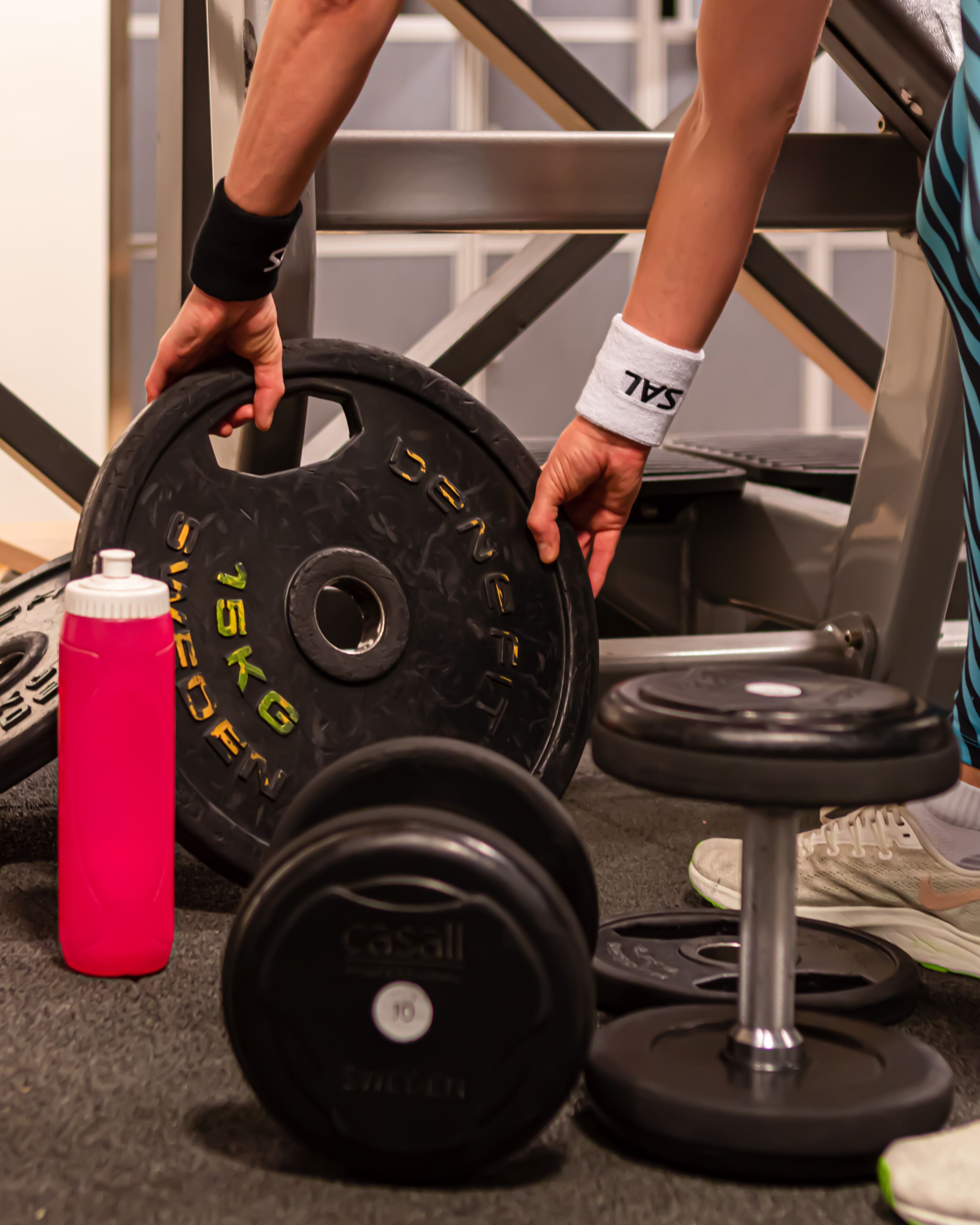 A gym setting with weightlifting equipment, including a barbell and dumbbells.