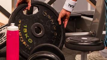 A gym setting with weightlifting equipment, including a barbell and dumbbells.