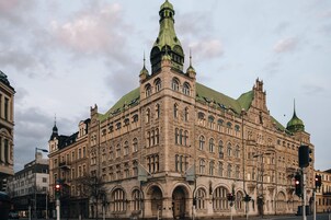 Un edificio histórico con múltiples torres y ventanas de arco, probablemente un hotel.
