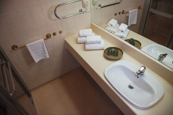 A bathroom with a sink, mirror, and towel rack.