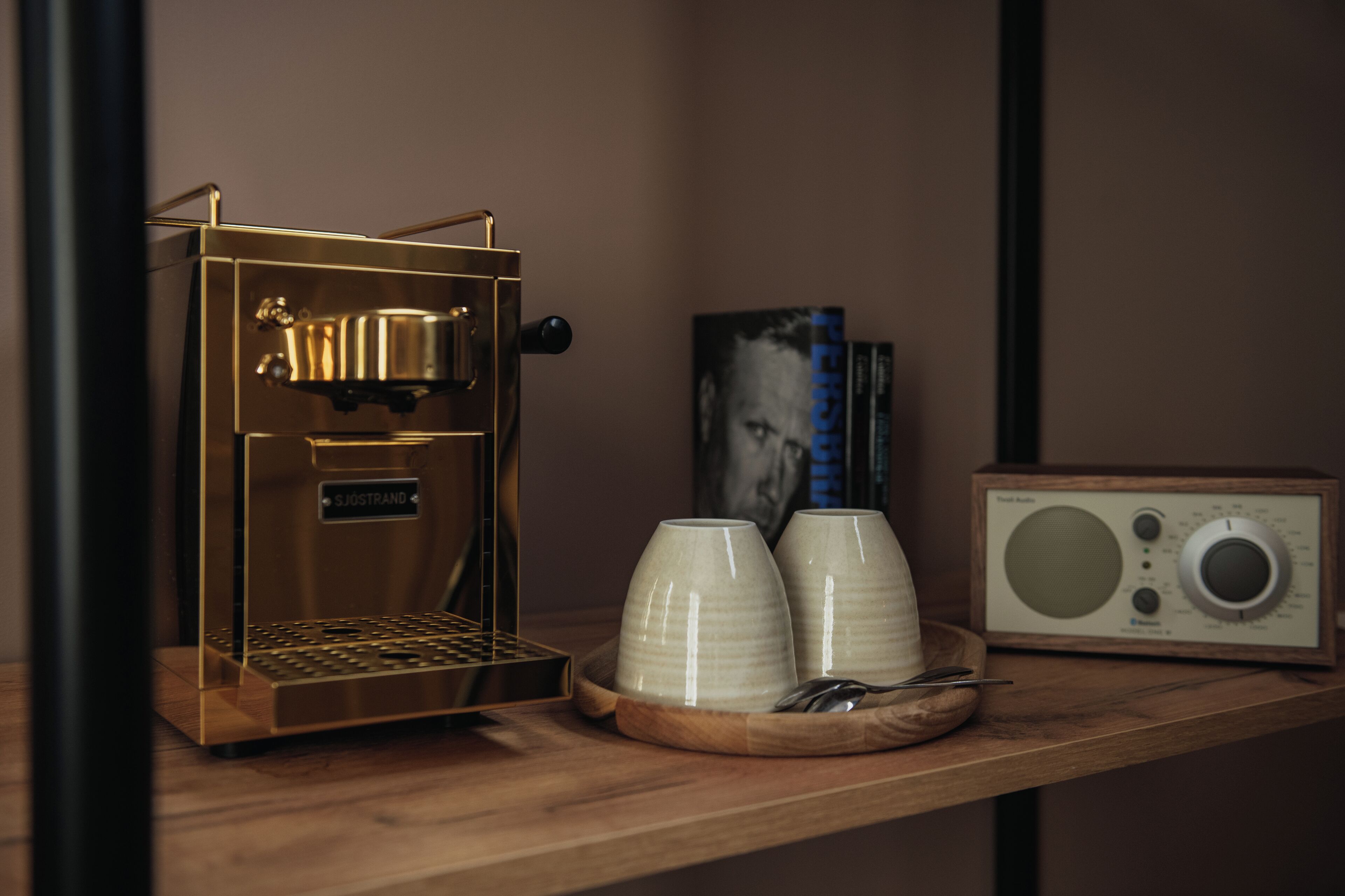 En kaffemaskin och en radio står på en hylla av trä.