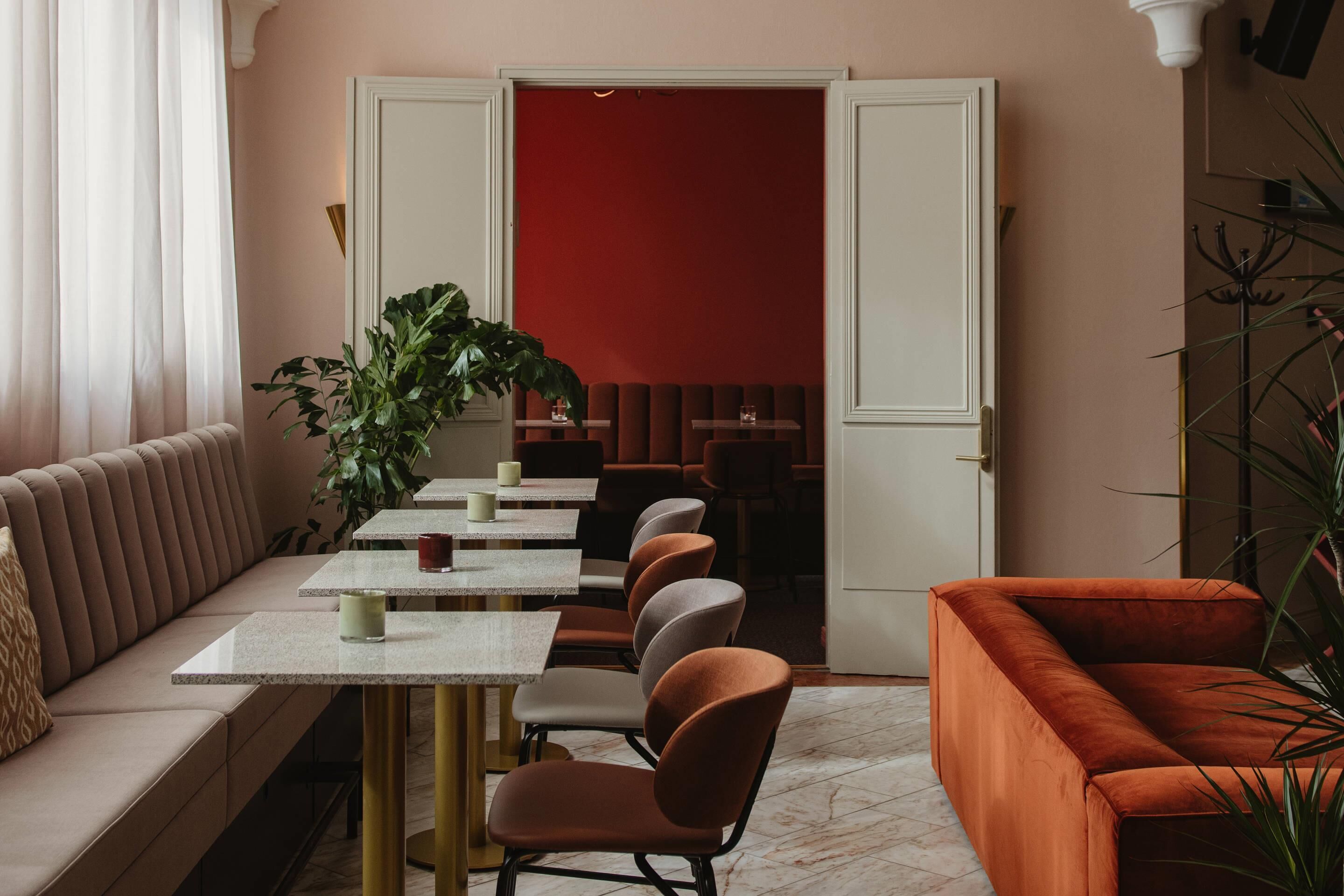 Un espace repas moderne comprenant un canapé, des tables et des chaises.
