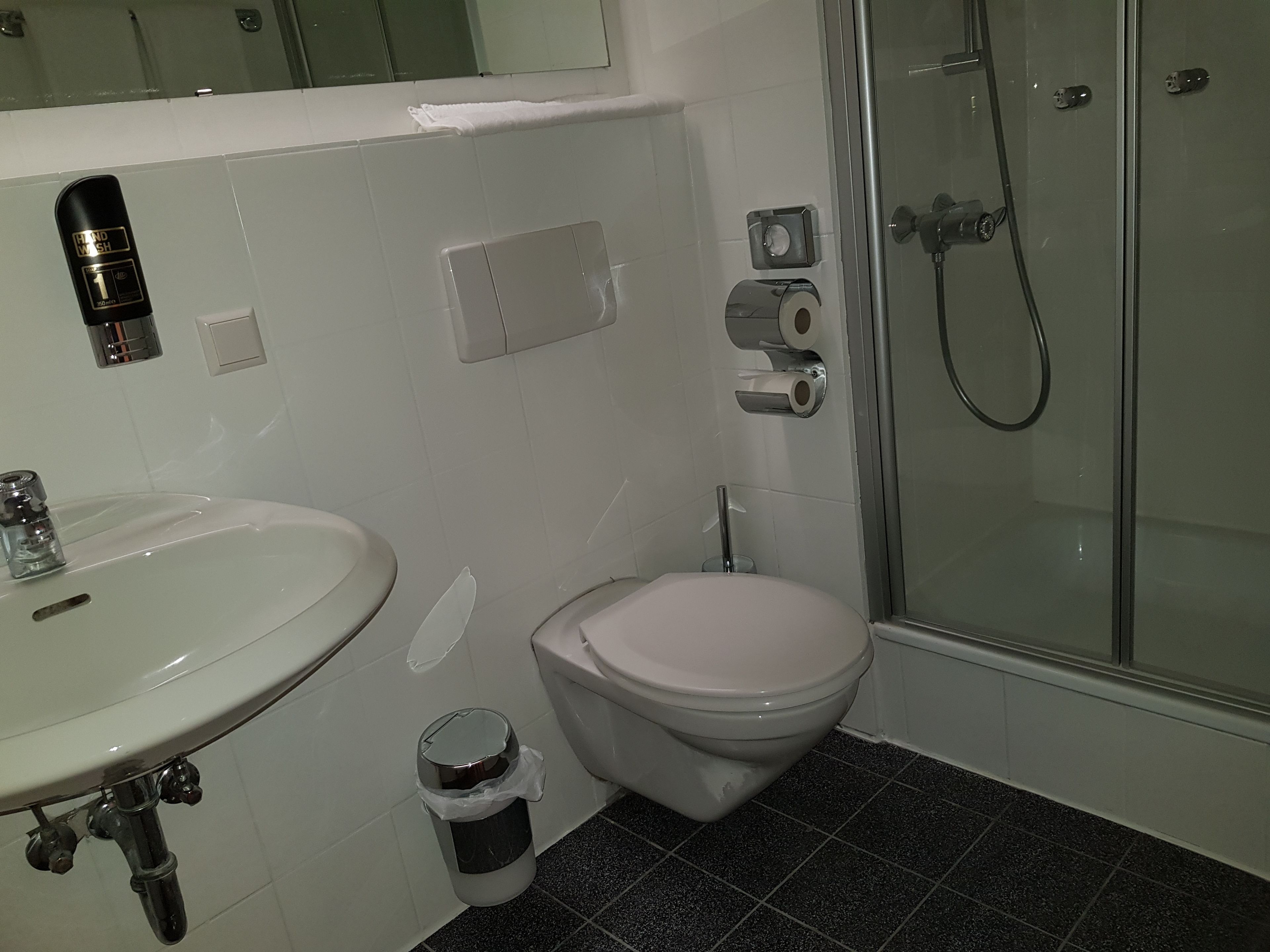 Un baño con lavamanos blanco, inodoro y cabina de ducha de vidrio.