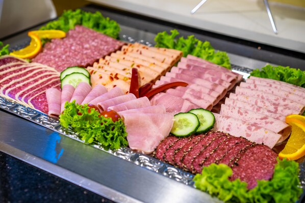 Una variedad de carnes y verduras cortadas dispuestas en una bandeja.